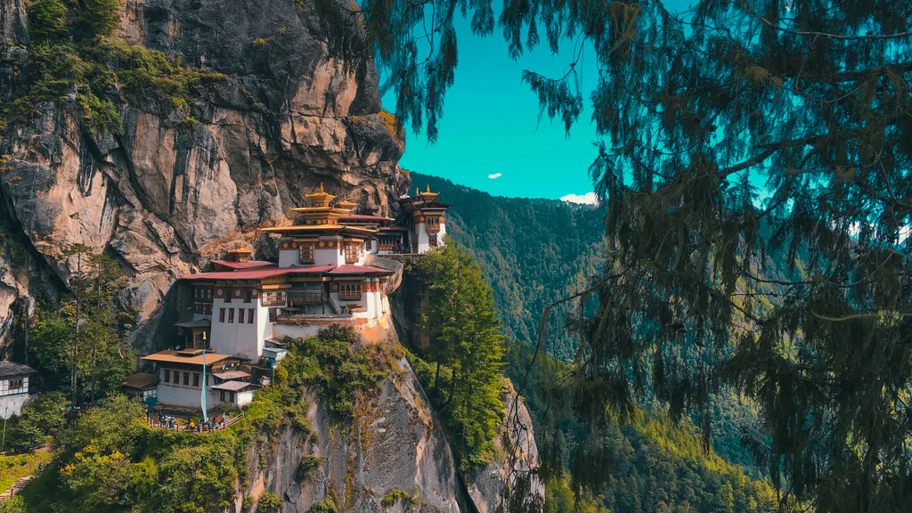 An image of Paro Taktsang, In Bhutan it is a Bhutanese monastery perched on a clifftop. The monastery is surrounded by mountains and overlooks a valley.