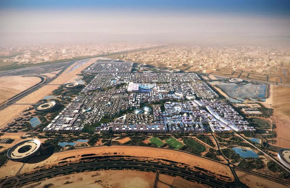 An aerial view of a masdar city UAE top places to travel with skyscrapers and high-rise buildings in the center, surrounded by desert landscape.