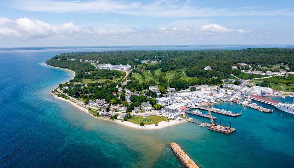 An aerial view of a small island town, Mackinac Island, Michigan, in the United States, in the middle of blue water.