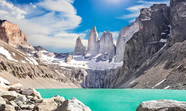 This image is of Patagonia Chile argentina  crystal-clear blue lake reflecting the snow-capped peaks of majestic mountains.