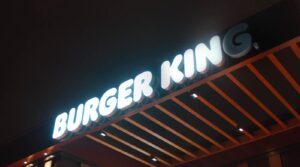 A brightly lit Burger King sign at night, with the letters "BURGER KING" in white against a dark background.Is Burger King open on Labor Day