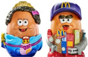 Two McDonald's adult Happy Meal toys: a female character with a crown and a male character wearing a baseball cap, both with large heads and friendly expressions.