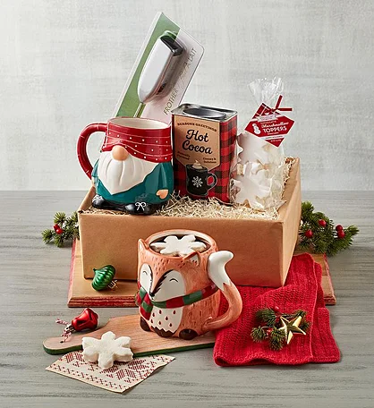 A Christmas gift box filled with hot cocoa items. It includes two mugs featuring holiday characters, a tin of hot cocoa mix, marshmallows, and a snowflake-shaped marshmallow maker. food gifts for christmas 