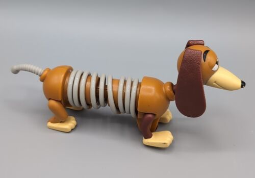 A Slinky J.D. the Dog
 toy from the Toy Story franchise Burger king. The toy is a dachshund with a brown body, floppy ears, and a gray slinky for a middle section. The toy is posed on its side, with its tail curled.