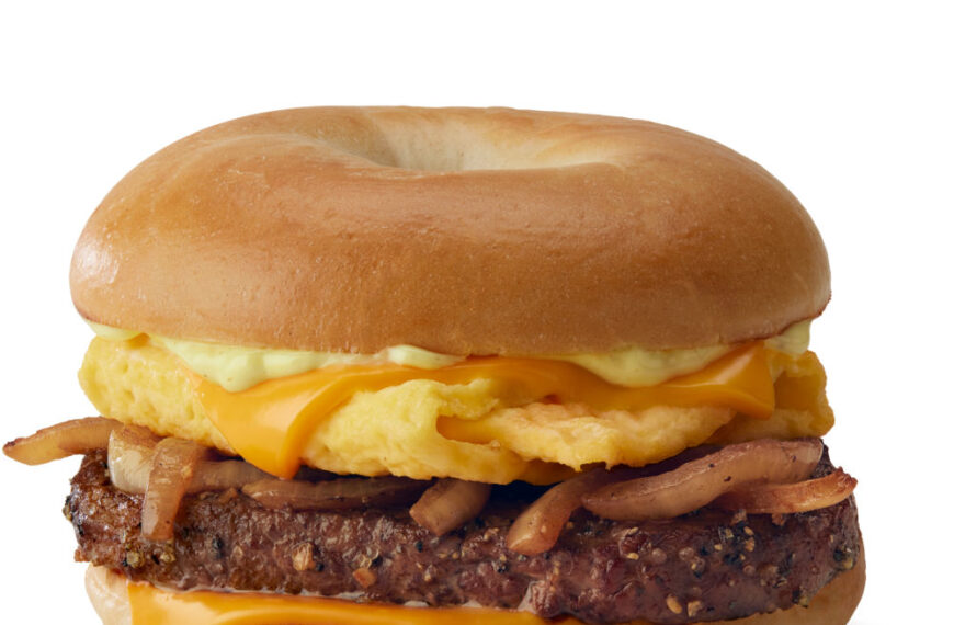 A McDonald's Breakfast steak Bagel recipe with a beef patty, scrambled eggs, cheese, and onions on a toasted bagel.