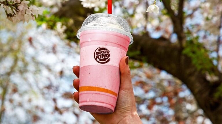 The image is of burgerking milkshake in the hands of someone and it reflects does burger king have milkshakes